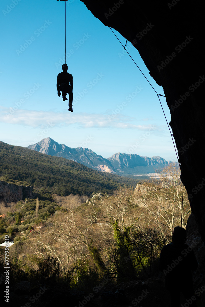 the climber hangs on a rope in a cave