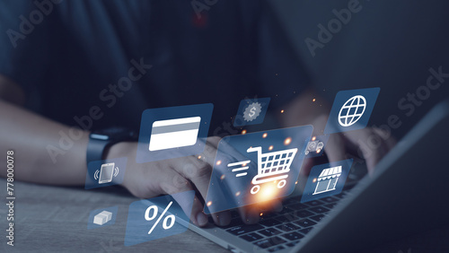 A person is using a laptop with a shopping cart icon on the screen. Concept of online shopping and the convenience of using a laptop for this purpose
