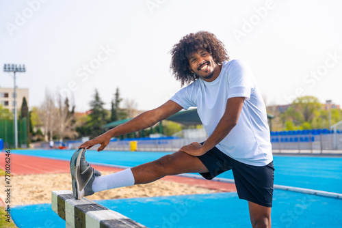 Sportive man warming up in an outdoor running track