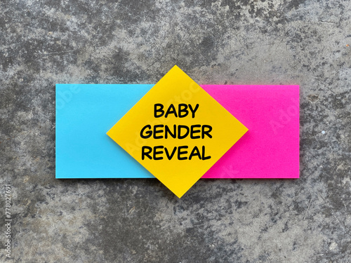 Motivational and inspirational wording. BABY GENDER REVEAL written on adhesive paper. Blurred styled background.