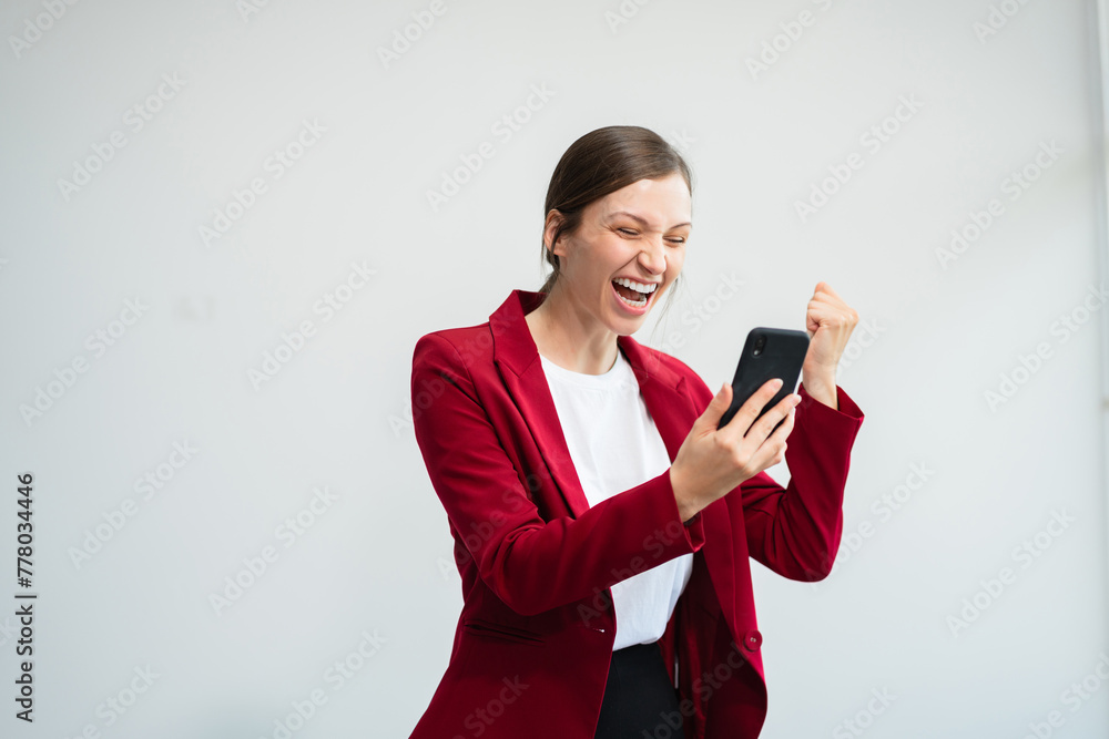 Happy excited woman using smartphone and receiving good news from the message on mobile chat application isolated over white background. Happy excited woman using smartphone and receiving good news from the message on mobile chat application isolated over white background.