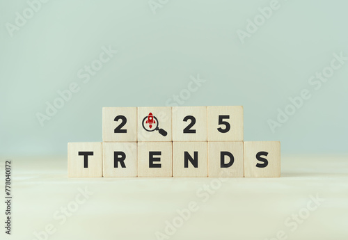 2025 trends, emerging markets concept. Wooden cube blocks with 2025, magnifying glass, TRENDS text. Used for banner in trend concept in new year for monitoring new business opportunities.