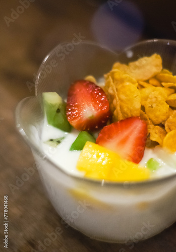 Homemade granola on black plate Overhead schoot of granola with nuts mix, yogurt, fresh berries and honey on blue plate voor healthy breakfast, top view, copy space.