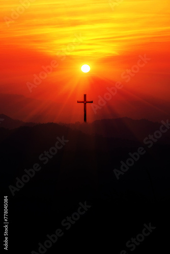 Silhouette of christian cross on the mountain at sunset.