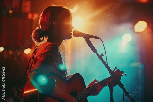 A young singer on a stage singing a song with guitar