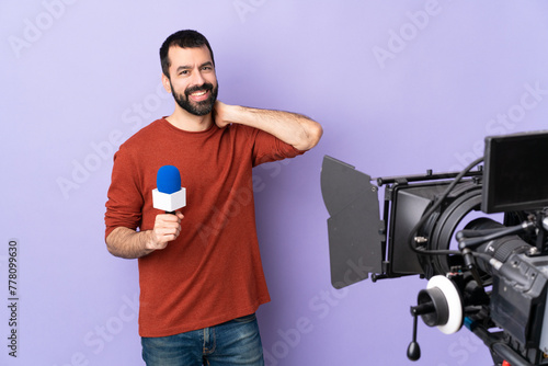 Reporter man holding a microphone and reporting news over isolated purple background laughing