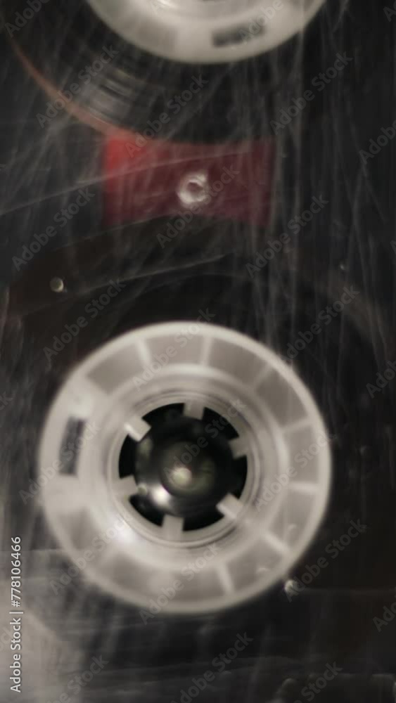 Retro cassette tape deck closeup loop. Record player playing old transparent audio cassette. Vertical video.