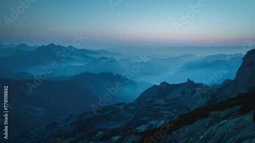 Layer upon layer of mountain ranges enveloped in mist under the ethereal twilight sky. photo