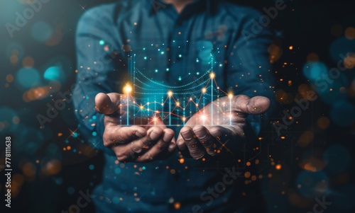 A man is holding a glowing graph with an upward arrow. Concept of progress and growth, as the upward arrow suggests that the graph is increasing or improving © Nathamanee