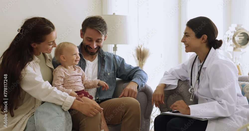 Loving parents and their baby visited paediatrician, sit o sofa lead talk, telling about health complaints to friendly female pediatrist during home-call. Professional medical services, regular check Loving parents and their baby visited paediatrician, sit o sofa lead talk, telling about health complaints to friendly female pediatrist during home-call. Professional medical services, regular check