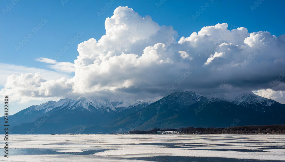 Thunderclouds over a frosty bay with mountains, dramatic sky with cumulus clouds, nature and meteorology abstract background