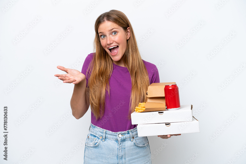 Young pretty blonde woman holding fast food isolated on white background with shocked facial expression Young pretty blonde woman holding fast food isolated on white background with shocked facial expression