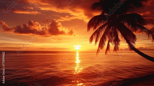 A vibrant orange sunset illuminates palm trees on a tropical beach.