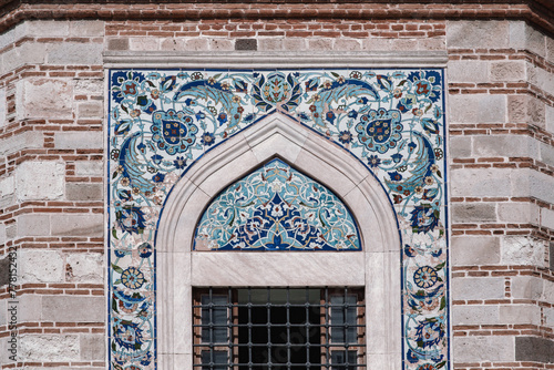 Vibrant iznik tilework of Konak or Yali Mosque at Konak square in Izmir, 18th century Ottoman architecture masterpiece with its intricate tile work and elegant minaret, under a clear blue sky photo