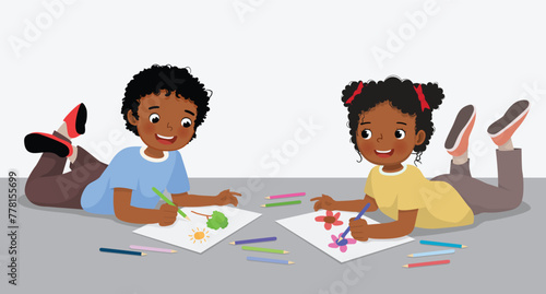 Cute little African kids drawing painting together lying on the floor
