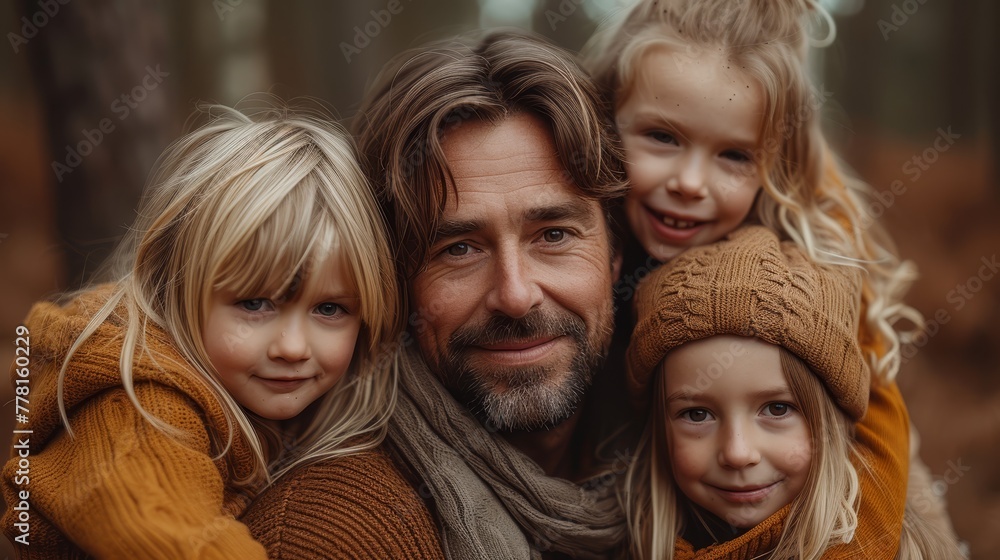 a man with two little girls and a man in a brown sweater posing for a picture in a wooded area. a man with two little girls and a man in a brown sweater posing for a picture in a wooded area.