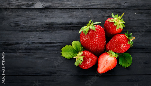 Strawberry on black wooden background with copy space for text