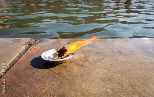 holy offerings oil lamp at river shore on religious occasion at morning from flat angle photo