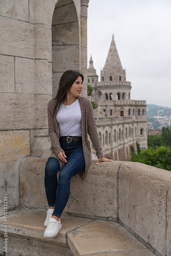 Young woman sitting looking to the side at the Fisherman's Bastion in Budapest Young woman sitting looking to the side at the Fisherman's Bastion in Budapest