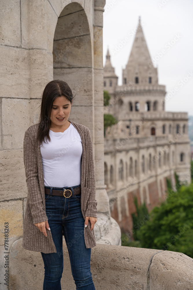 Beautiful young tourist woman posing with looking down at the famous Fisherman's Bastion in Budapest