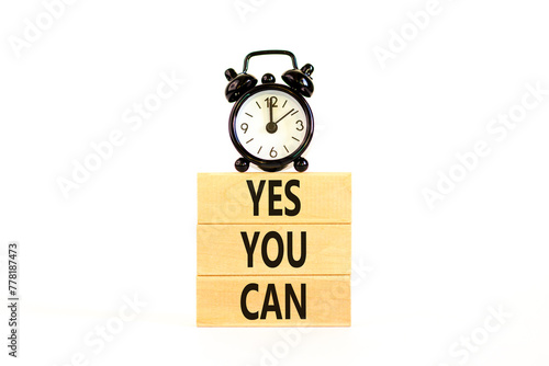 Motivational and Yes you can symbol. Concept words Yes you can on beautiful wooden blocks. Beautiful white background. Black alarm clock. Business motivational and Yes you can concept. Copy space.