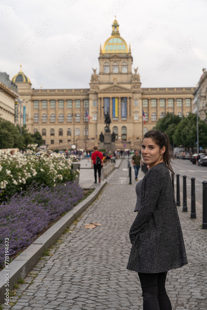 Young female tourist posing in front of Prague History Museum