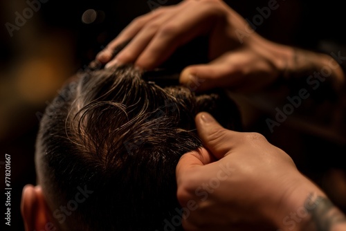 Close-up of a barber's hands styling a client's hair with precision, focusing on grooming details.