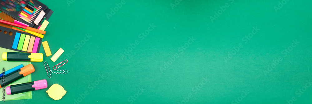 Back to school. Stationery on a green table. Office desk with copy space. Flat lay. Banner design. Back to school. Stationery on a green table. Office desk with copy space. Flat lay. Banner design.