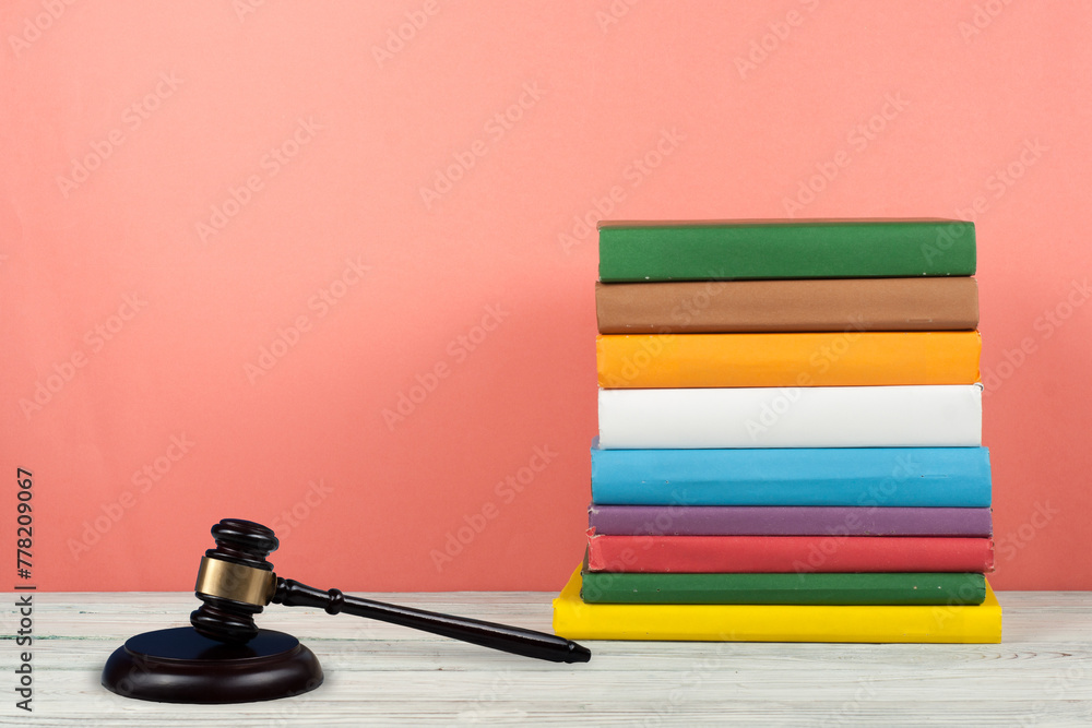 Law concept open book with wooden judges gavel on table in a courtroom or law enforcement office, pink Red background. Copy space for text. Law concept open book with wooden judges gavel on table in a courtroom or law enforcement office, pink Red background. Copy space for text.