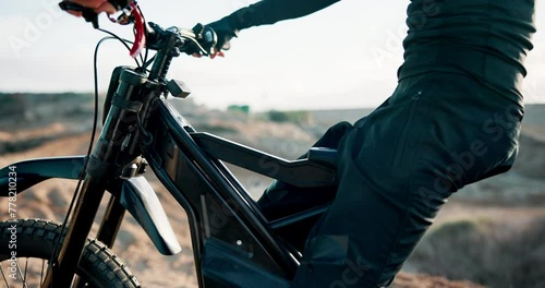 Biker, electric bike or man with seat in outdoor training to start for extreme sports, safety or practice on sand. Lift, ready or driver with gear for dunes, race or cycling in challenge on holiday photo