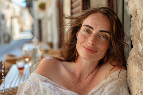 Redheaded woman over 35 with freckles enjoying local flavors at a cozy European cafe