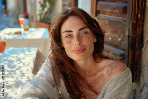 Redheaded woman over 35 with freckles enjoying local flavors at a cozy European cafe