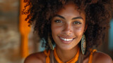 Lively beautiful Afro American young woman with curly hair, honey eyes, big round earrings on colourful background. Natural woman beauty concept. Selective focus 