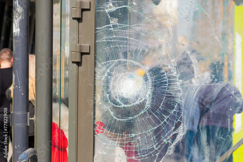 Broken glass at a public transport stop. anonymous people. close-up