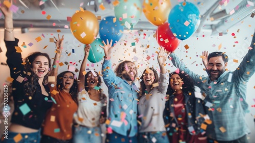 Diverse team of employees celebrating a success with confetti and balloons in a festive atmosphere