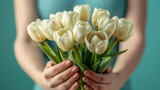 Bouquet of beautiful white spring tulips in women's hands.  Fresh spring composition on blurred background. Close up.