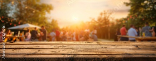 A wooden table with a group of people sitting around it. The sun is setting in the background, creating a warm and inviting atmosphere