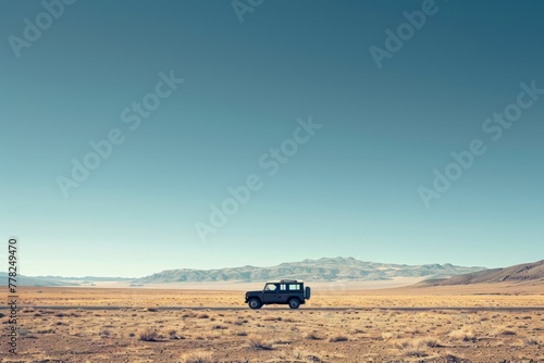 A truck drives through a desert landscape with mountains in the background under a clear sky