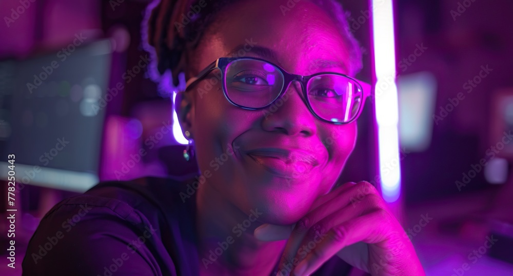 Black Woman in Dark Setting with Purple Reflection on Glasses Smiling Black Woman in Dark Setting with Purple Reflection on Glasses Smiling