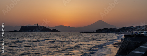 夕暮れの七里ヶ浜海岸から江ノ島と富士山のシルエットを眺める