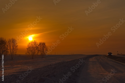 Russia, Southern Kuzbass. Colorful picturesque sunrise on a frosty morning in snow-covered fields. photo
