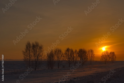 Russia, Southern Kuzbass. Colorful picturesque sunrise on a frosty morning in snow-covered fields.