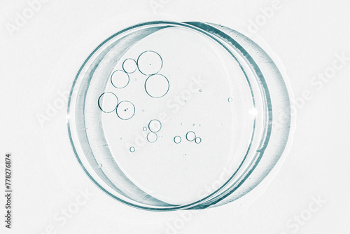 Petri dish. Petri's cup with liquid. Chemical elements, oil, cosmetics. Gel, water, molecules, viruses. Close-up. On a white background.