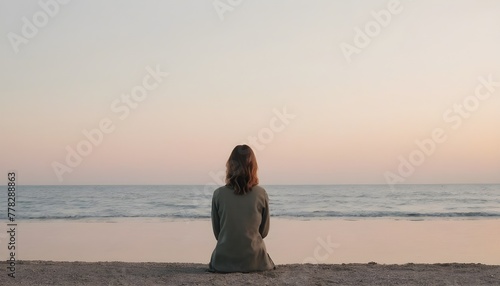 Backshot of a woman sitting on a beach. peaceful. pastel. 