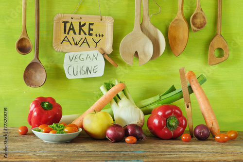Fresh veggies take away and food delivery service with fresh vegetables,wooden kitchen utensils and promotional sign.Vegetarian lifestyle,eat trend, celebrate healthy food concept