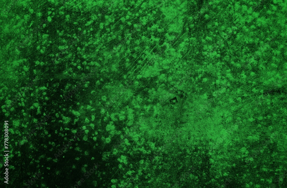 Fototapeta premium A textured green grunge background with dark patches and rough surface