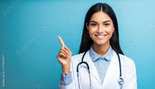 Smiling happy doctor pointing with finger on blue background photo