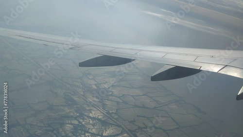 The view from the airplane window. Flying above the blue sky with moving clouds. Traveling on airplane at clear weather day.