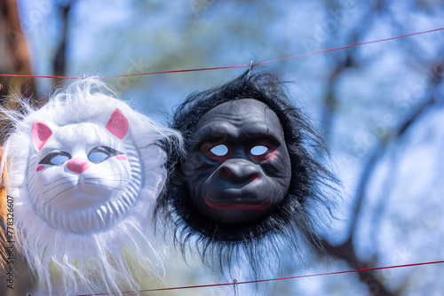 Handmade mask of monkey and cat animal mask hanging at fair. Selective focus. photo