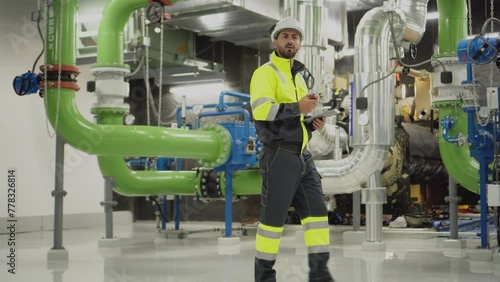 engineer work on chiller plant. worker checking pipe on chiller water plant